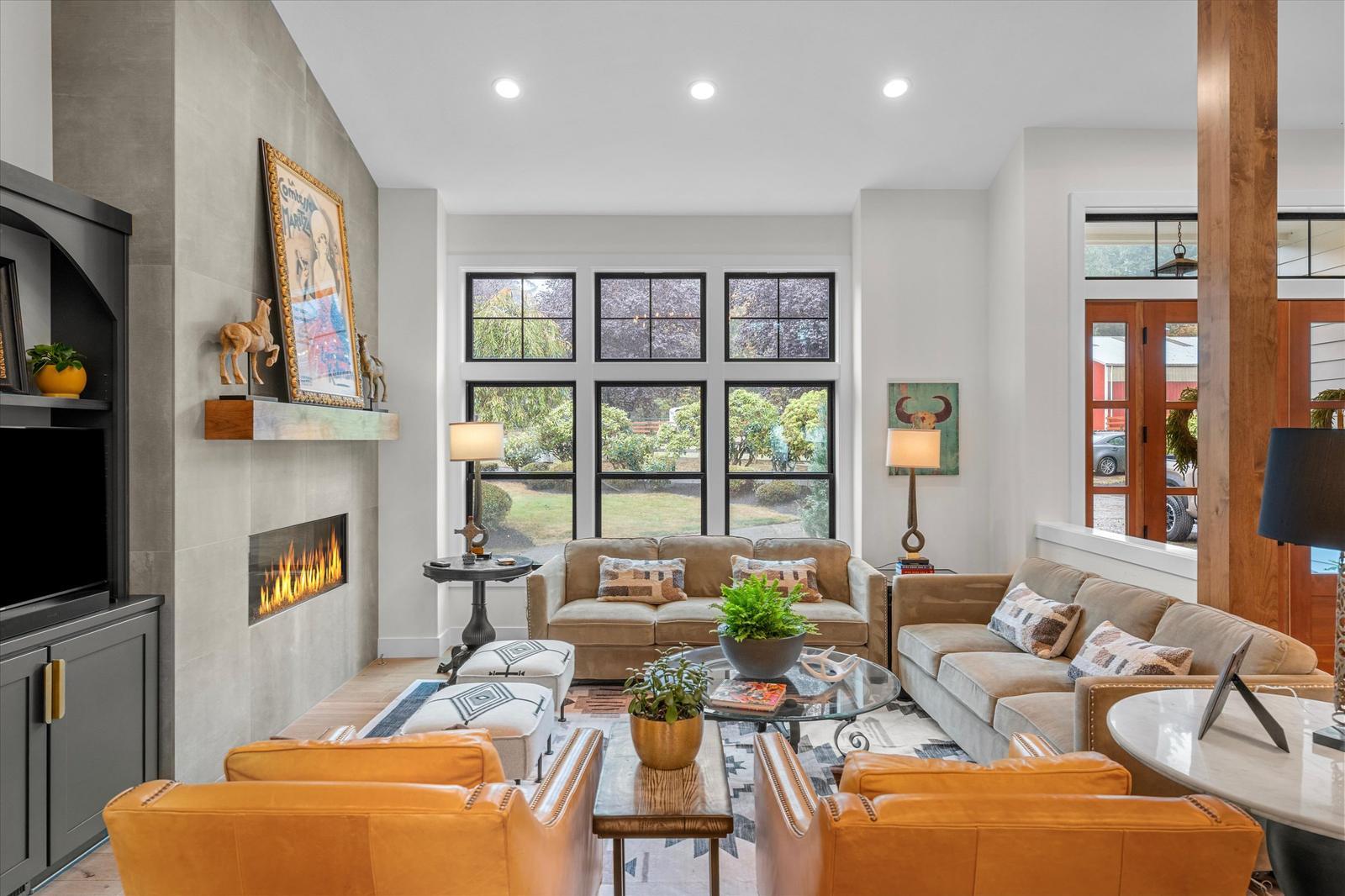 Main living room with linear fireplace and tall windows